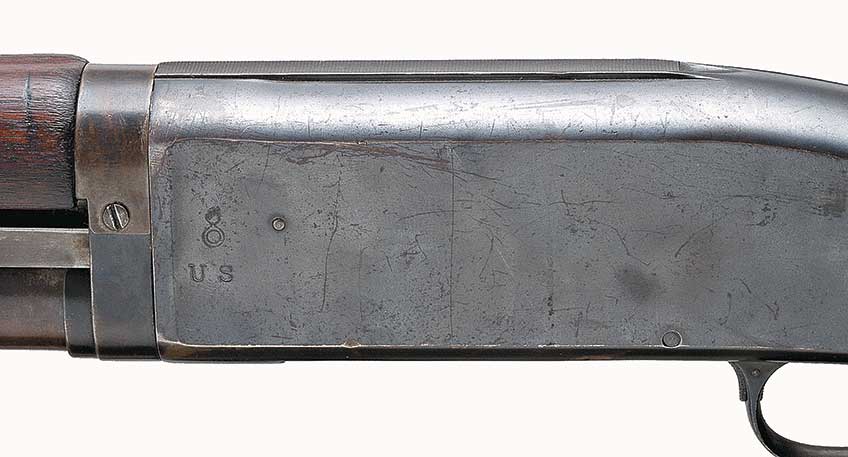 The receivers of Remington Model 10 trench guns were marked with “US” and the “flaming bomb” insignia on their left sides.