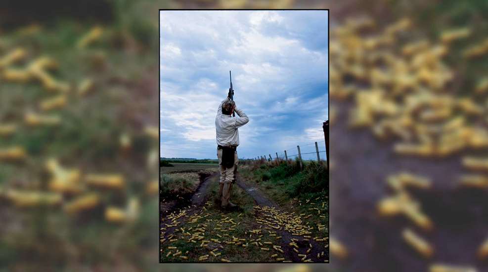 In the field with sub-gauge shotgun shooting outdoors hunting shotshells yellow hulls scattered ground blue sky