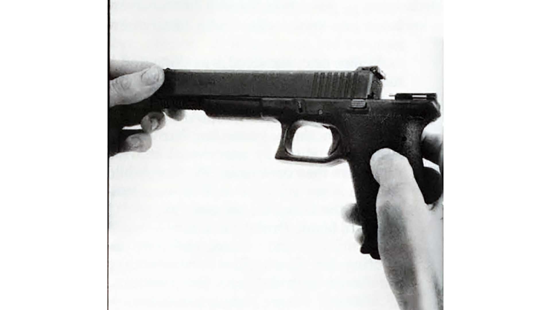 A hand removing the slide of a Glock 17 pistol from its frame.