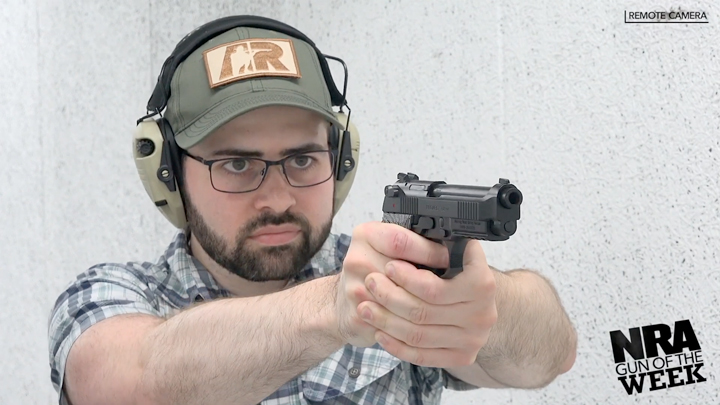Man with beard and ballcap shooting a pistol.