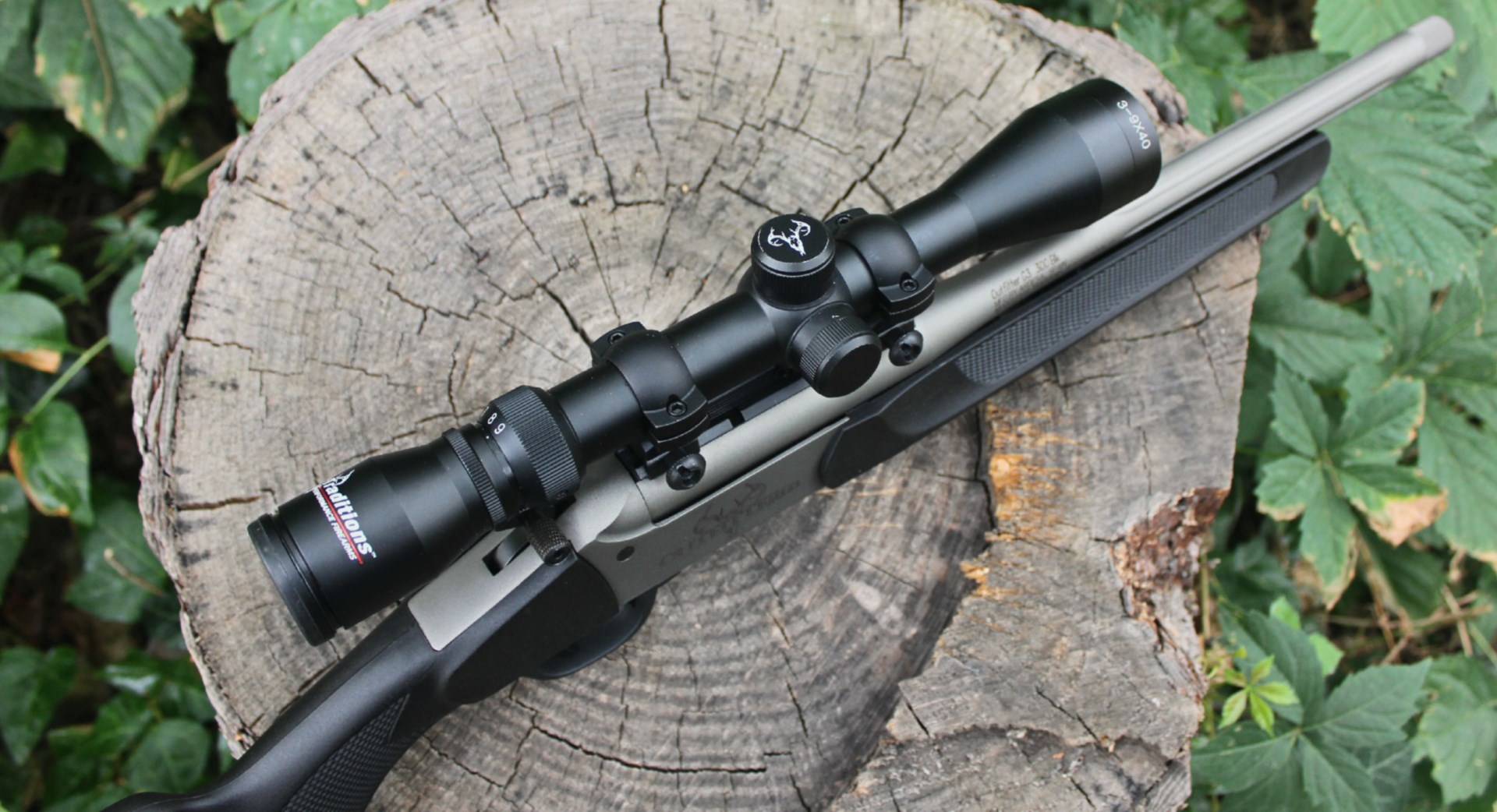 Traditions Outfitter G3 top-down view resting on log with green leaves to show compactness of the single-shot carbine