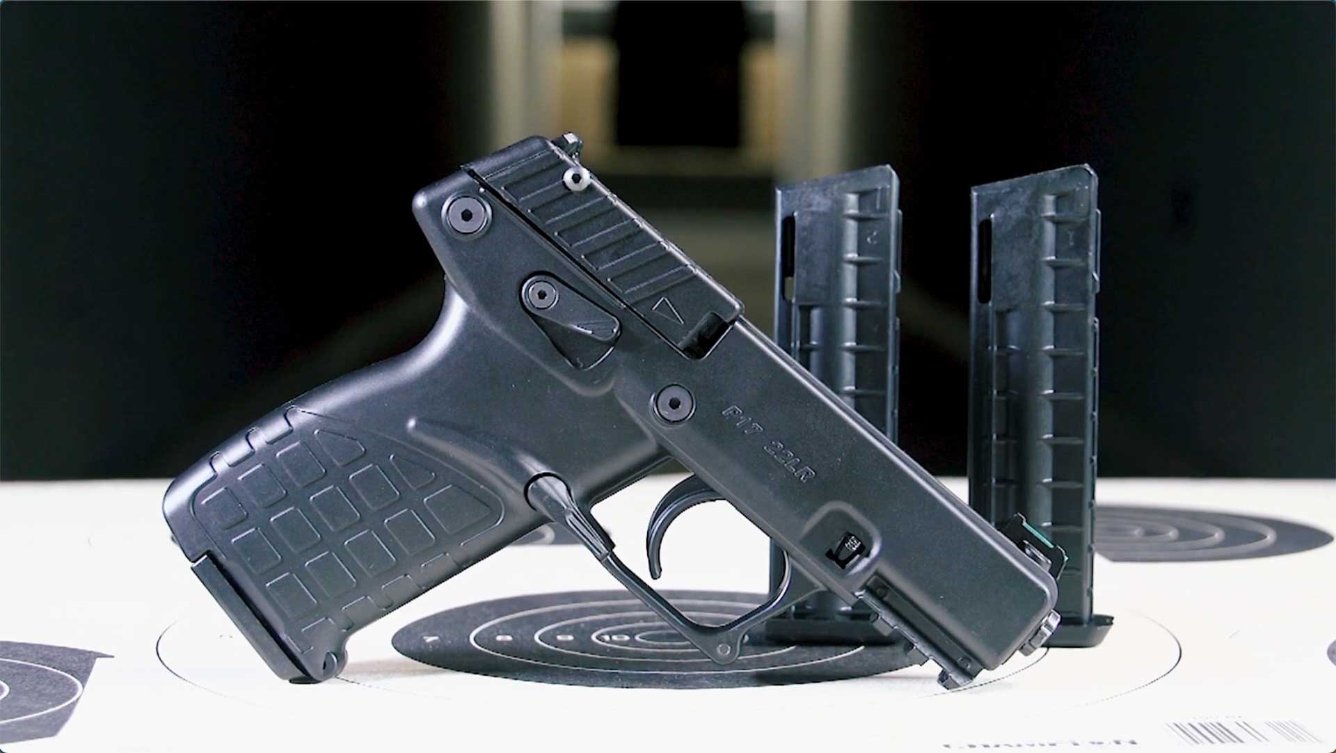 Right side of the black KelTec P17 shown on a dark range, alongside two spare magazines.