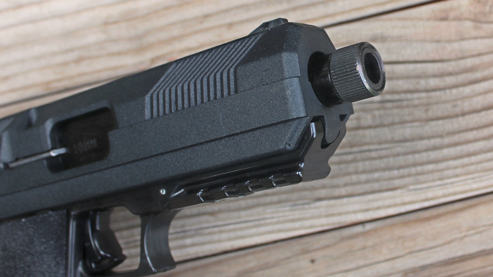 hi-point jxp 10 muzzle closeup pistol gun slide frame shown on wood boards