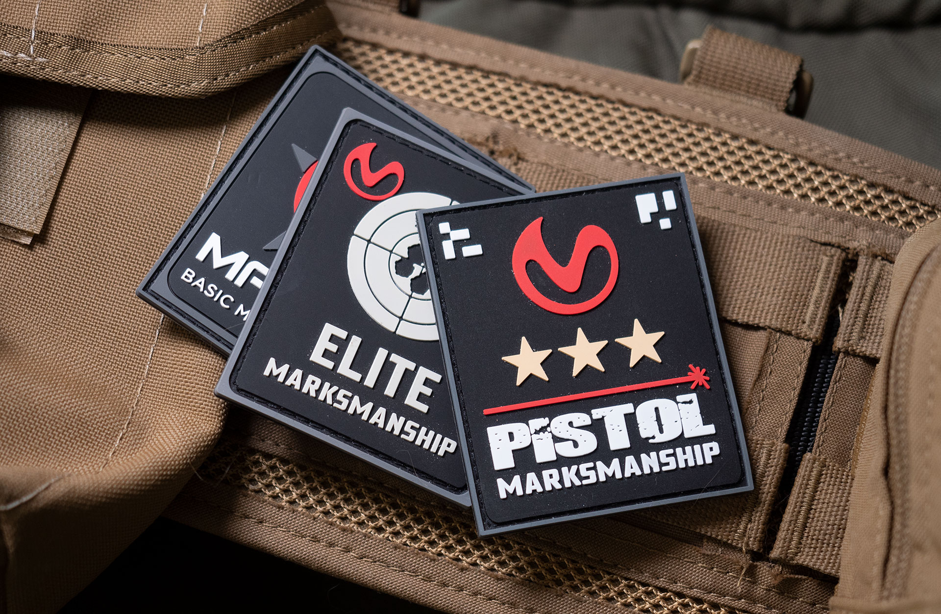 Mantis Laser Academy patches laid out on tan gear.