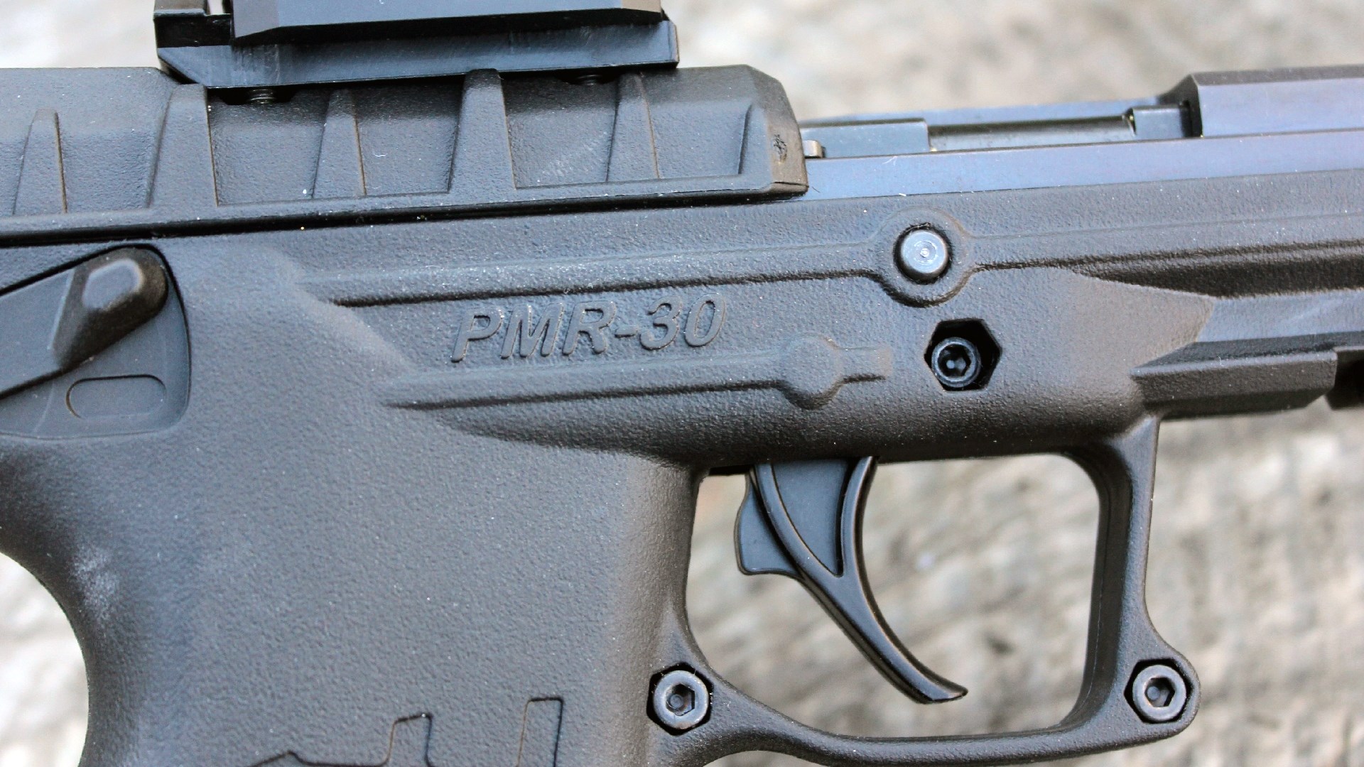Keltec PMR-30 pistol handgun rimfire semi-automatic close-up image of stamp on right side of frame above trigger forward of safety lever below red-dot sight optic