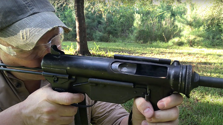 Aiming the M3A1 with the built-in, non-adjustable, stamped iron sights.