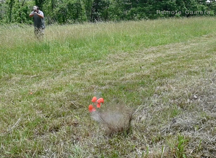 Man standing in a field shooting a bouncing clay target.