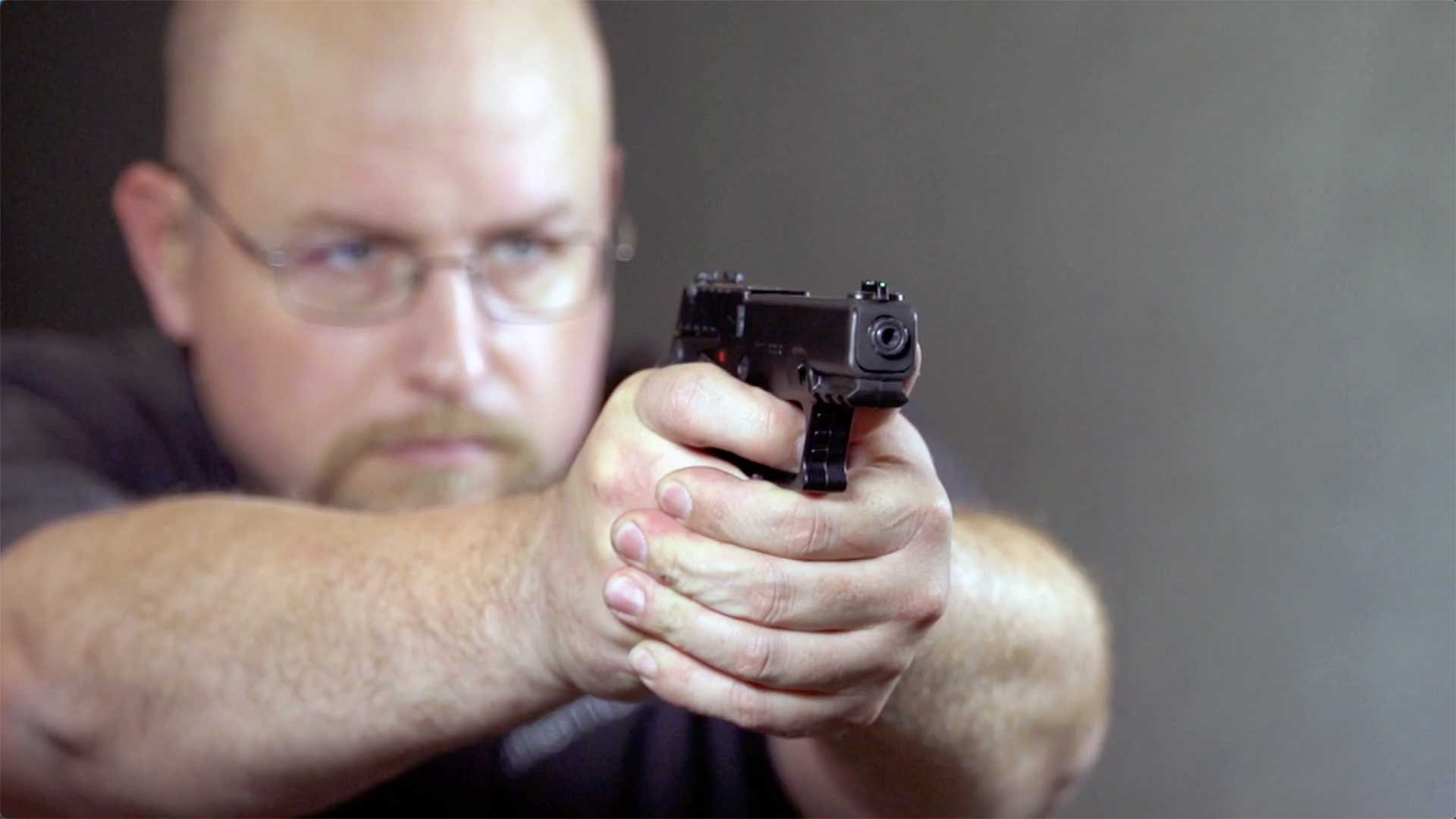 A man aiming the KelTec P17 downrange.