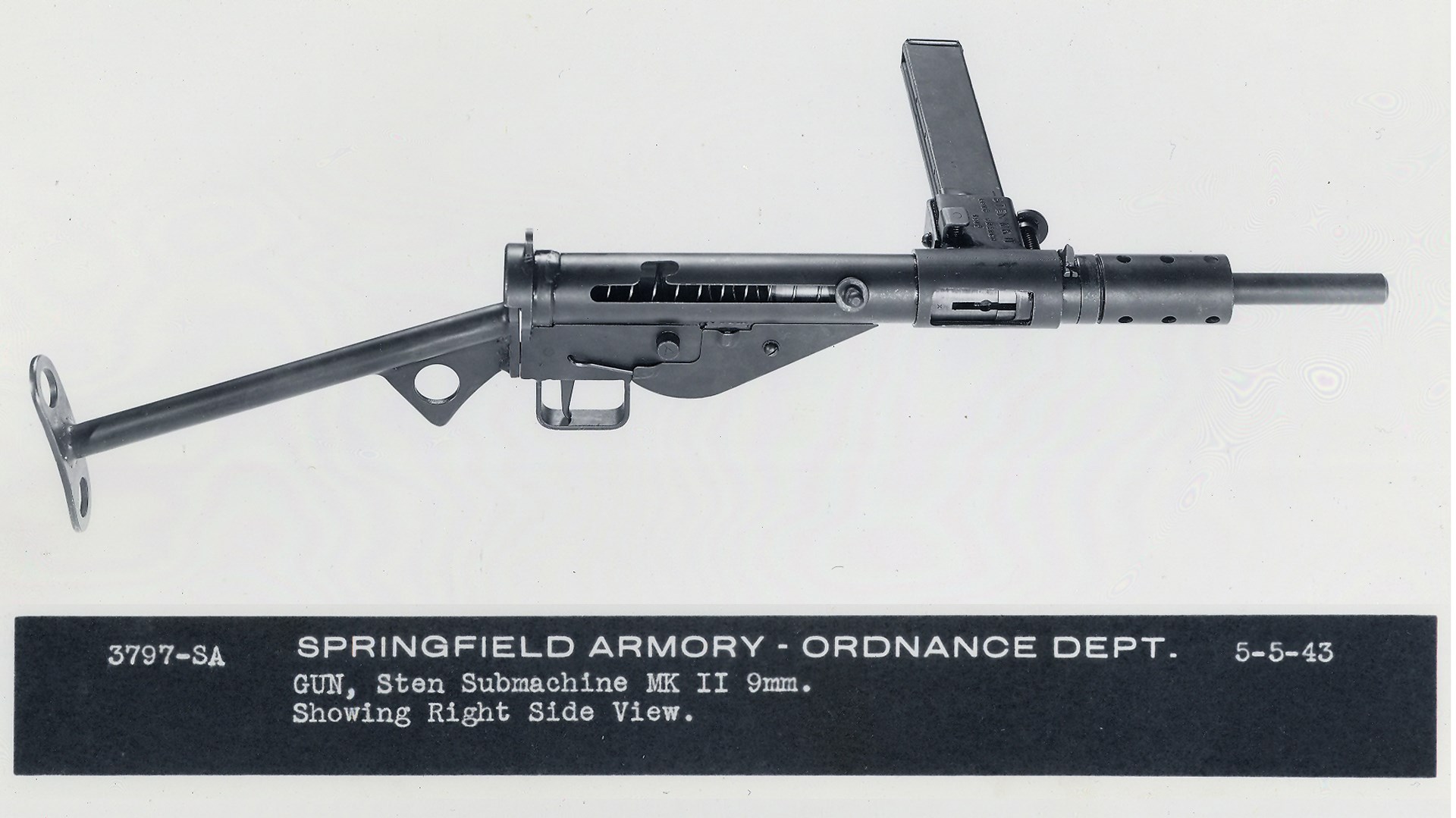 Right-side view of British Sten Gun Sten MKII shown with photo caption noting: SPRINGFIELD ARMORY ORDNANCE DEPT 5-5-43 3797-SA GUN, STEN SUBMACHINE MK II 9MM. SHOWING RIGHT SIDE VIEW.