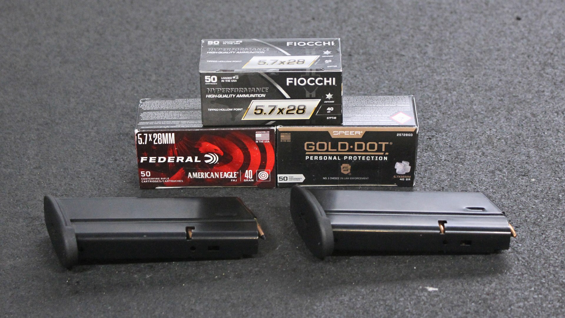 5.7x28 mm ammuntion boxes, three, shown with two black detachable box magazines