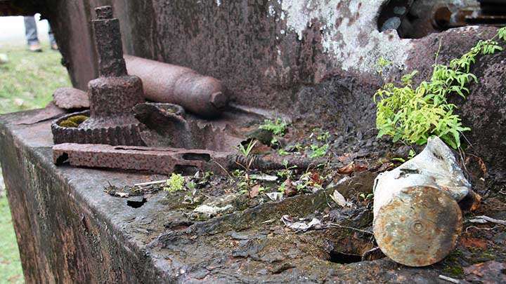 The upper receiver of a relic condition M1928A1 Thompson submachine gun sits on the left side track sponson of an LVT(A)-4 AmTrac located near the end of one of the runways of Peleliu’s old airfield.