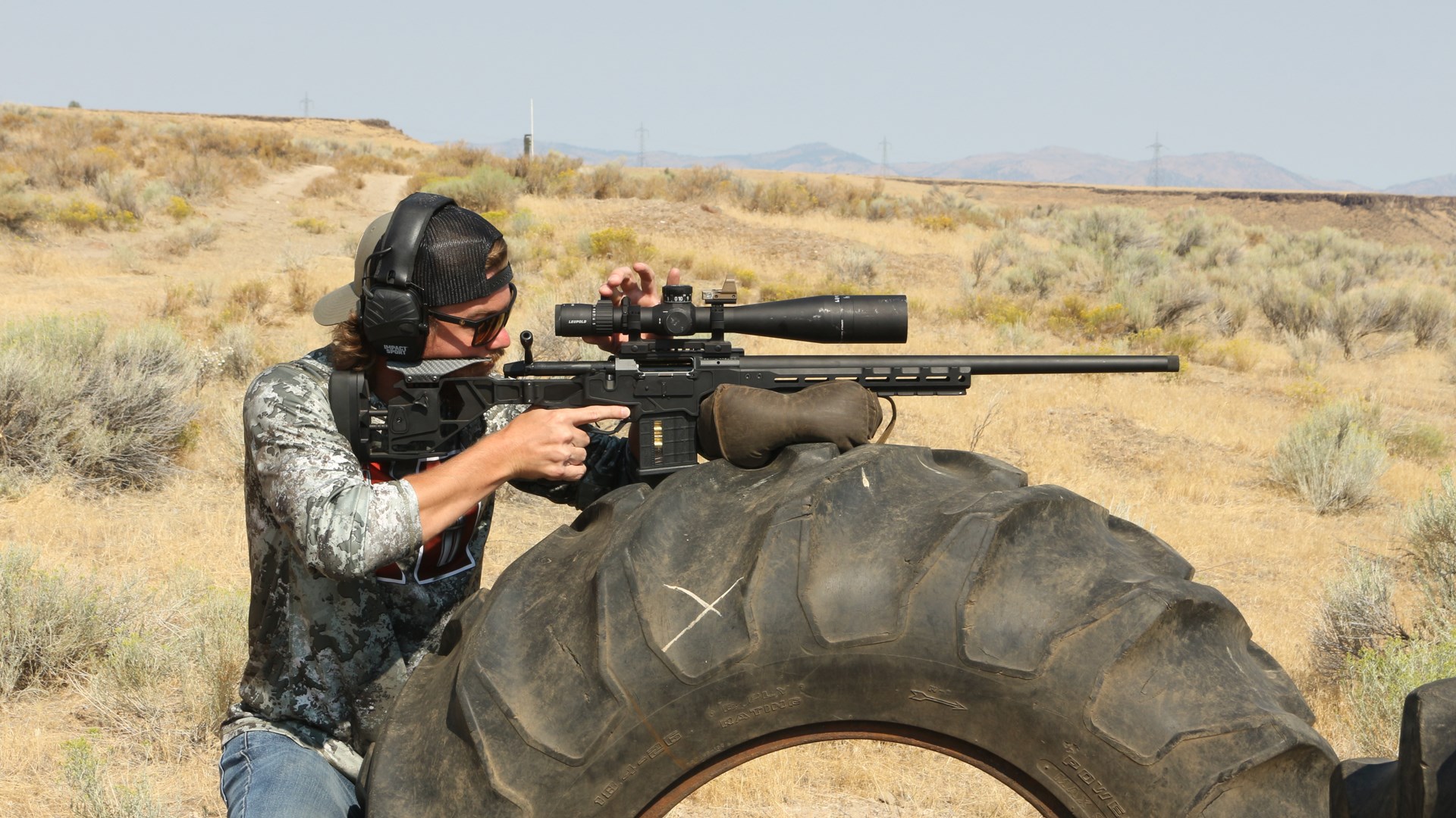 Recoil Recovery drill with shooter shown on tire with rifle adjusting optic outdoor desert high plains arid