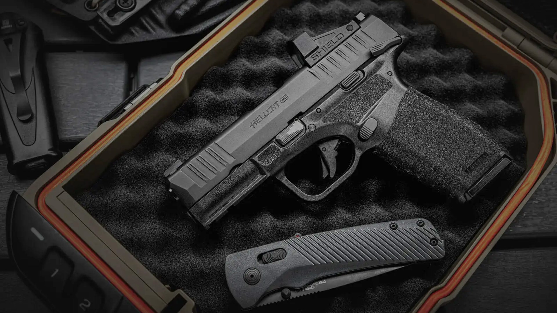 Springfield Armory Hellcat Pro OSP pistol left-side view resting with knife on eggcrate foam in gun safe