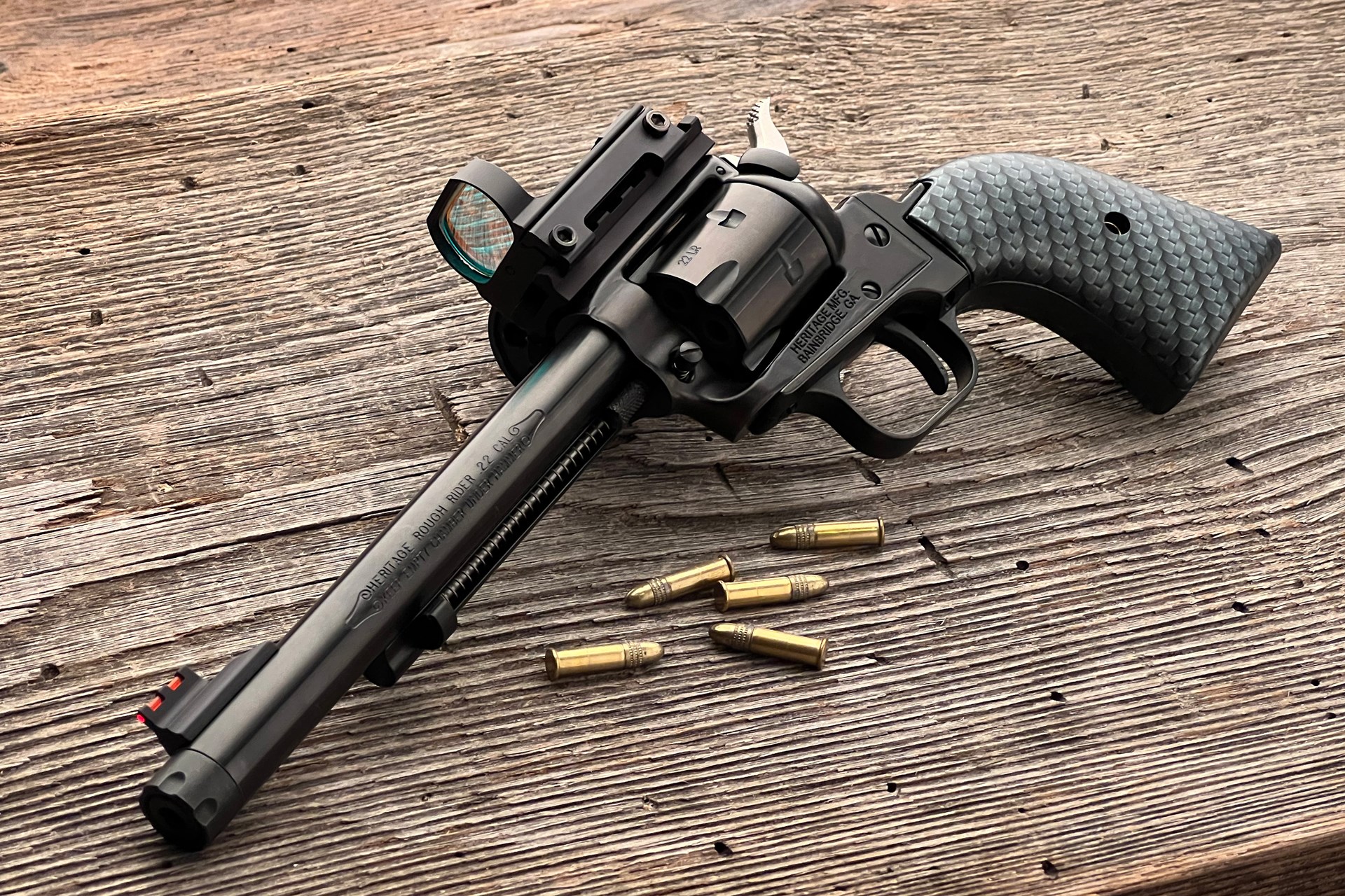 Heritage Manufacturing Tactical Cowboy revolver 22LR rimfire single-action gun with red-dot optic shown on wood background