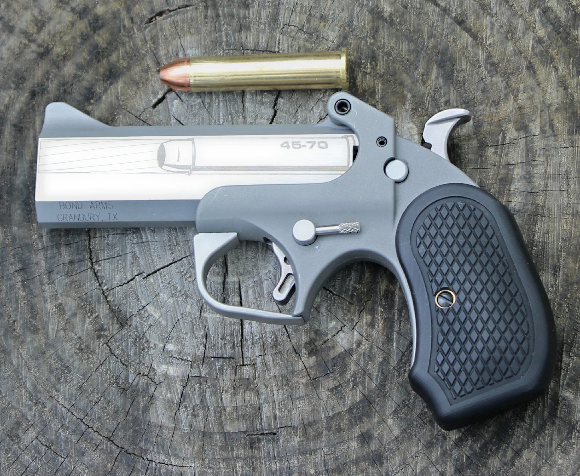 left-side view single-shot pistol bond arms cyclops .45-0 govt bullet cartridge wood background
