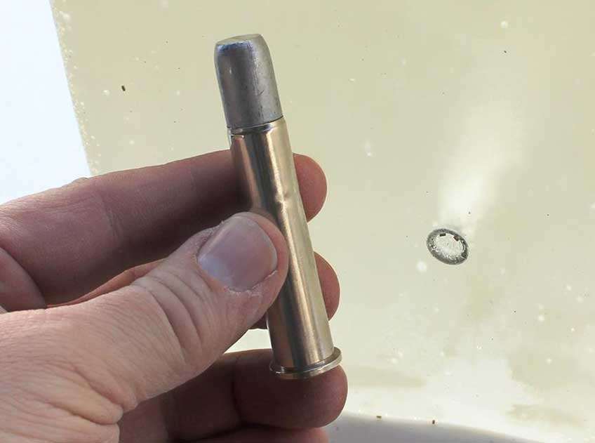 ammunition bullet cartridge .45-70 gov&#x27;t in hand next to gelatin block penetration testing