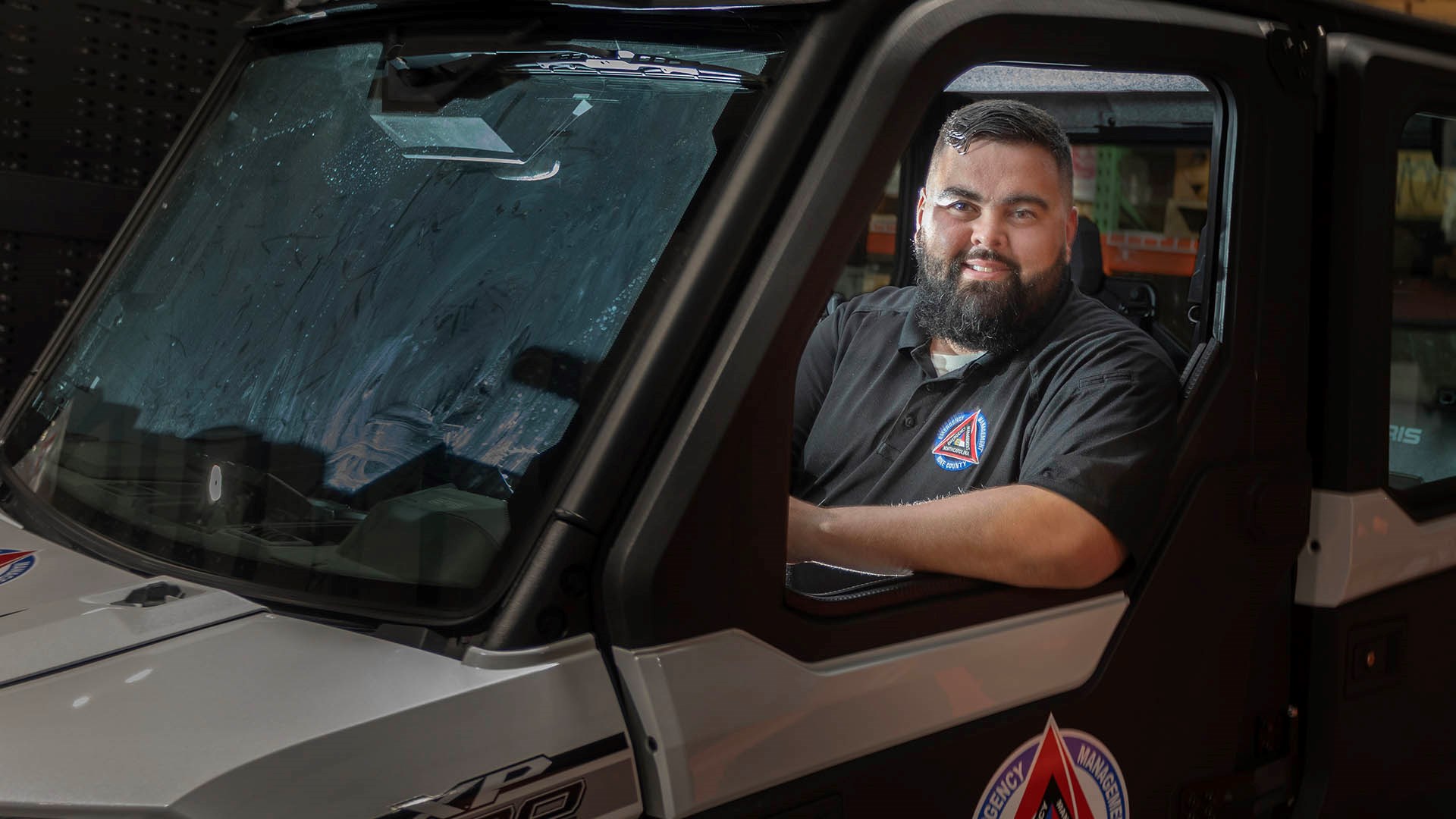 Man smiling in seat of UTV offroad vehicle NOAA employee first responder