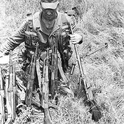A U.S. Ranger poses with a haul of AK-47s and a Czech vz. 52/57 light machine gun (7.62x39 mm). The vz. 52/57 used either metallic link belts or 25-round box magazines interchangeably. Its cyclic rate was 1,100 rounds-per-minute.