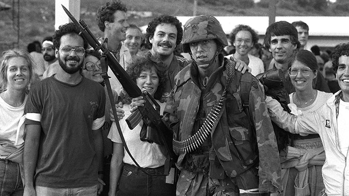 Liberated: American students at St. Georges University on Grenada pose with a trooper of the 82nd Airborne Division. He carries an M16A1 rifle equipped with an M7 bayonet.