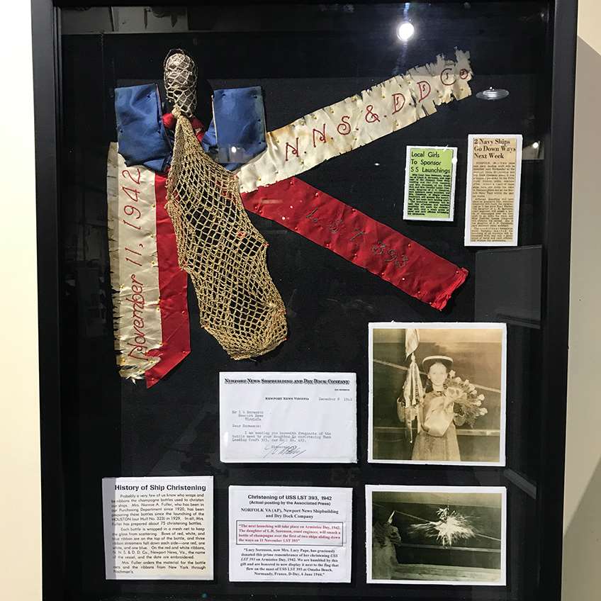 The original christening bottle from LST 393's launch on Nov. 11, 1942, along with the photos of the christener, Lucy Jean Sorenson, on display inside the ship's museum today.