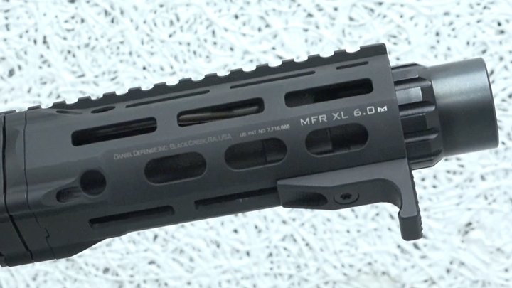 Black AR-15 handguard shown on dapled gray background.