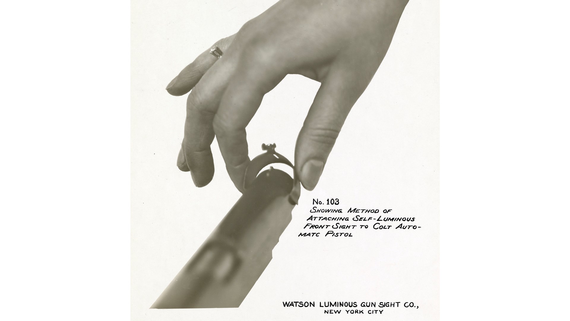 hand with ring placing part on gun luminuous paint vintage photograph text on image describing action