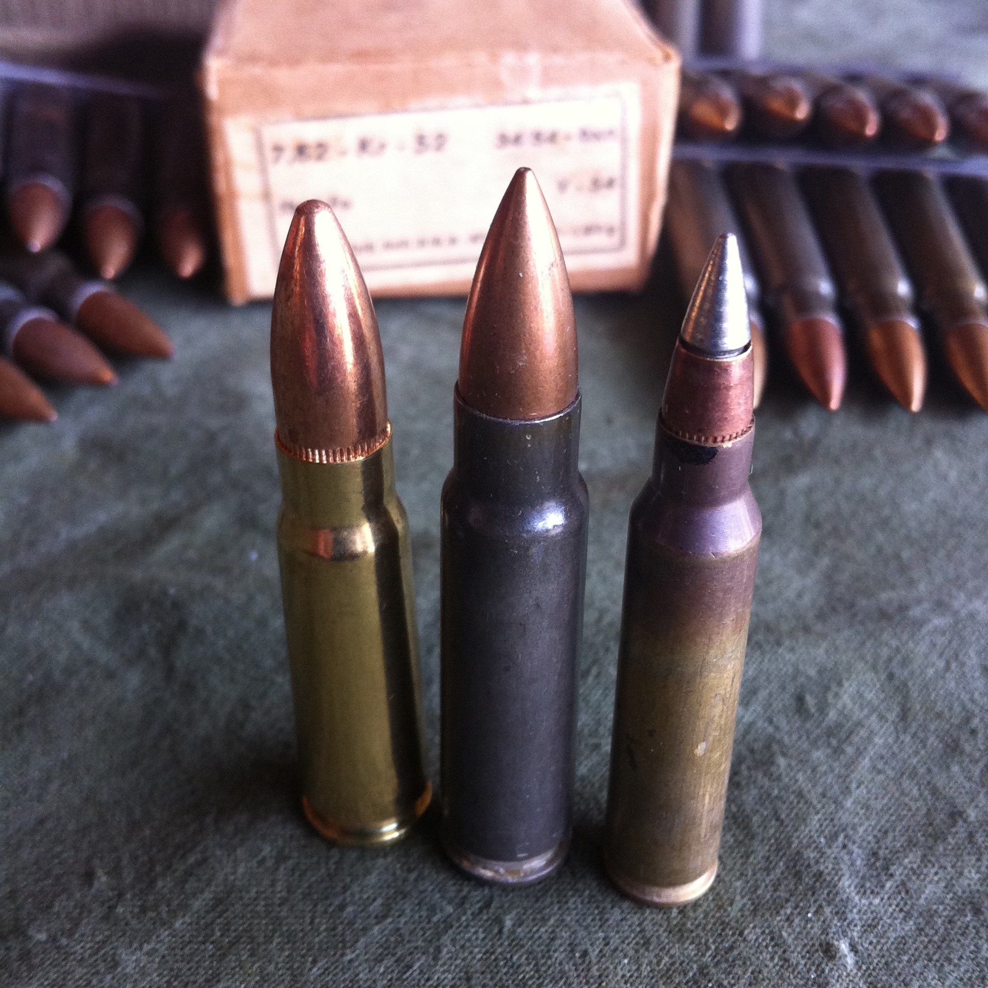 A 7.62×39 mm cartridge (left), a 7.62×45 mm cartridge (center), and a 5.56×45 mm M855A1 cartridge (right) are seen here together for comparison. In the background is an original box of Czech 7.62×45 mm ammunition and five stripper clips loaded with 7.62×45 mm cartridges for the vz. 52 rifle. Image courtesy of Martin K.A. Morgan.