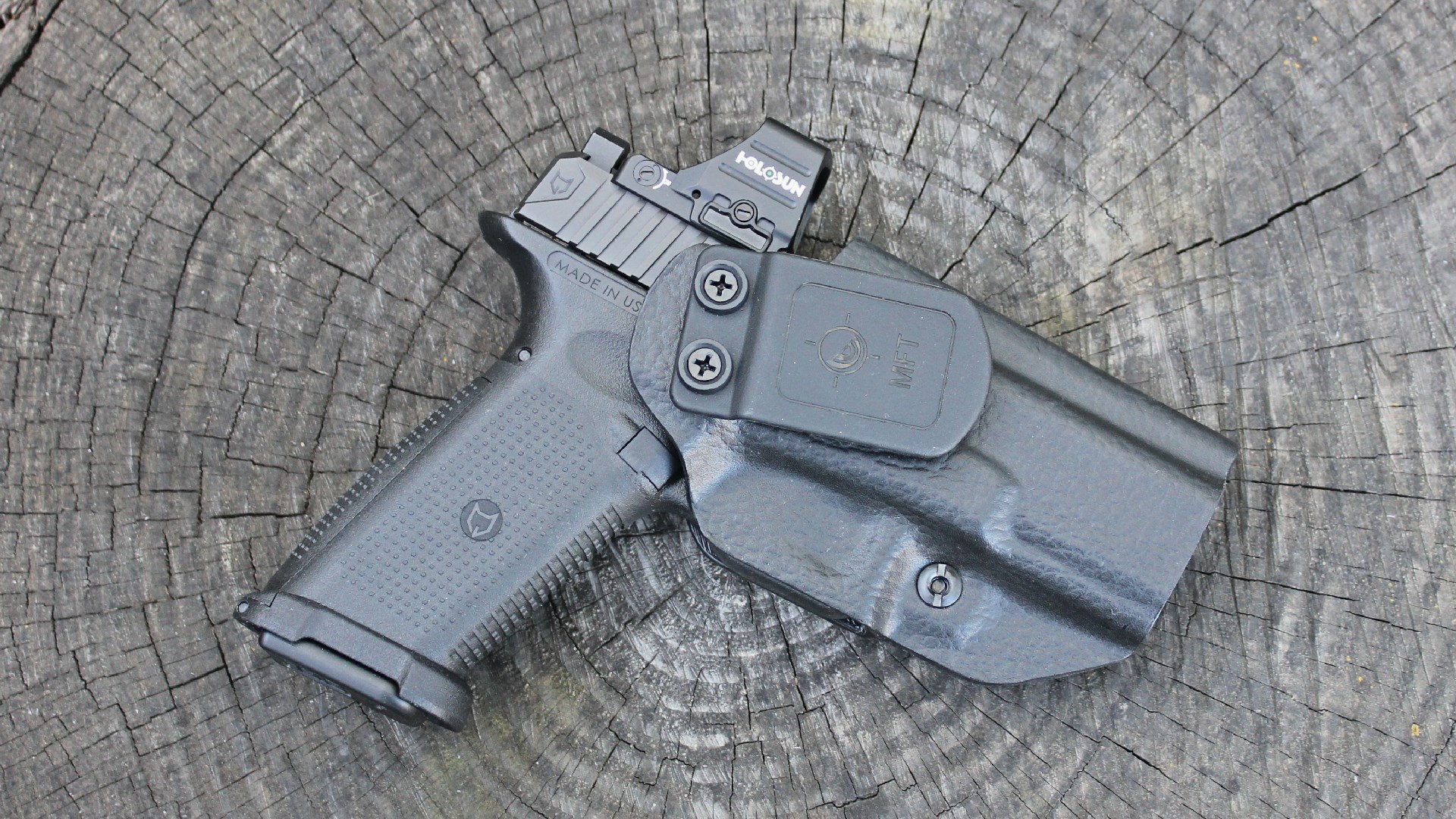 Lone Wolf Timberwolf 19X pistol black with holosun red-dot shown in leather-wrapped holster on log