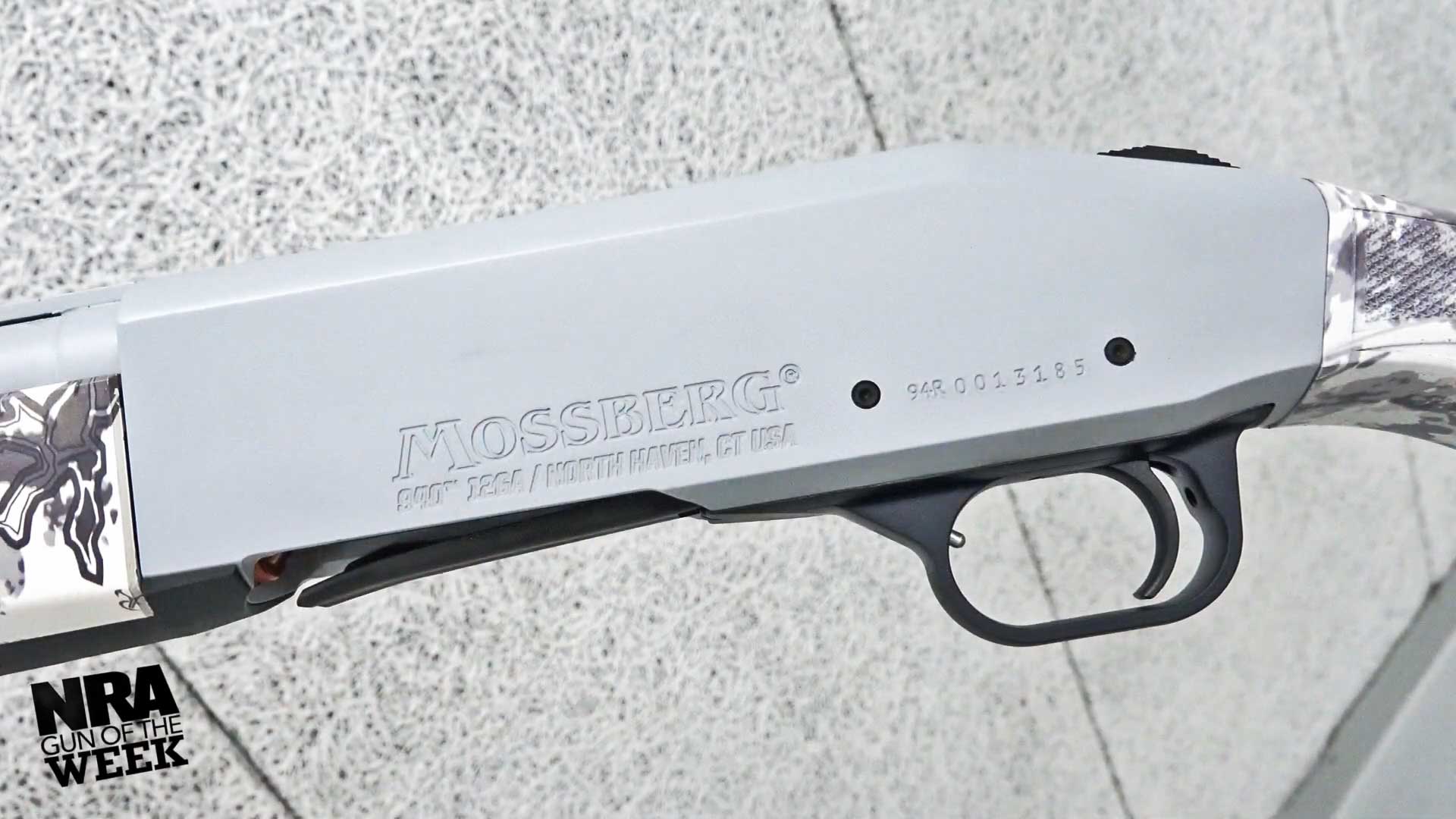 gray-colored aluminum shotgun receiver words stamped MOSSBERG
