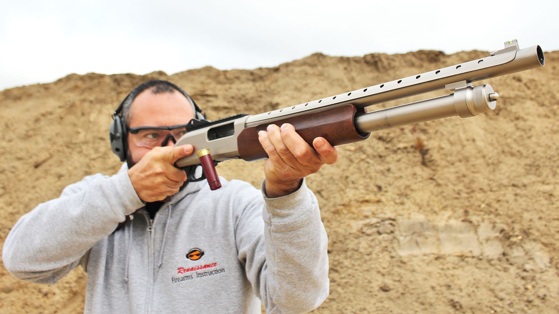 Shooting the Tokarev USA TX3 12HMD on the range, with the action racked back and a shell ejected.
