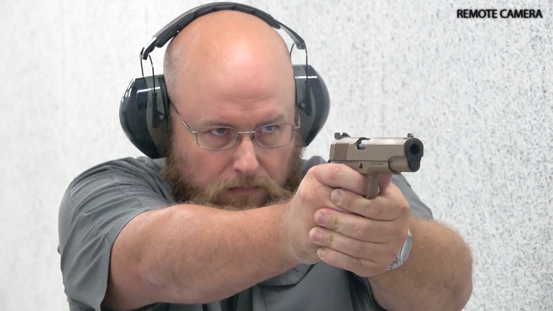 Man shooting Girsan MC1911S XLV pistol indoors wearing protective gear