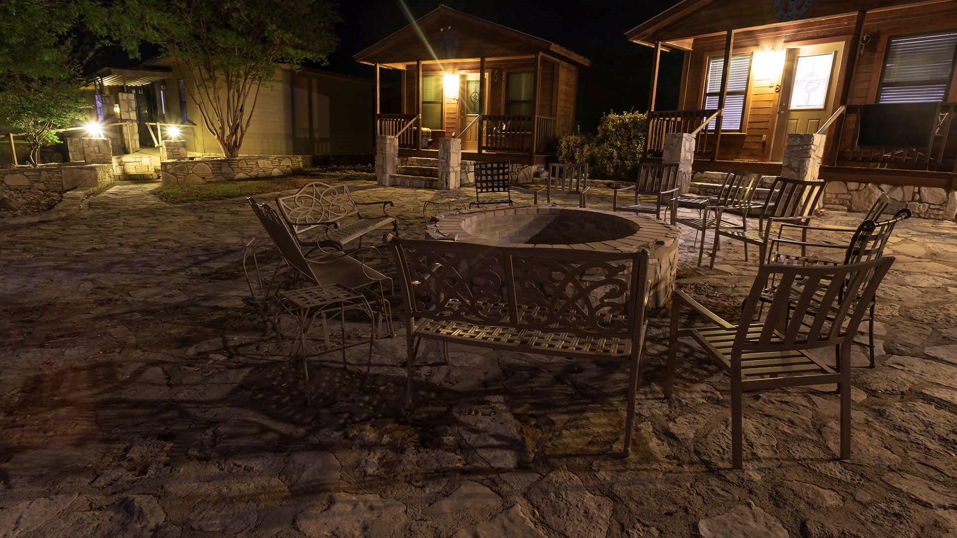 outdoor patio night with lights cabins chairs stone firepit
