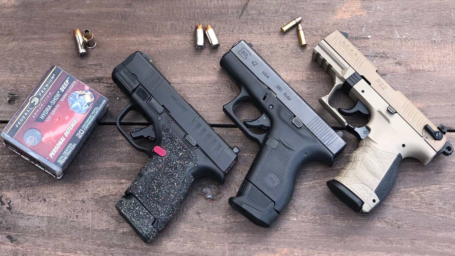 three pistols on table with ammunition