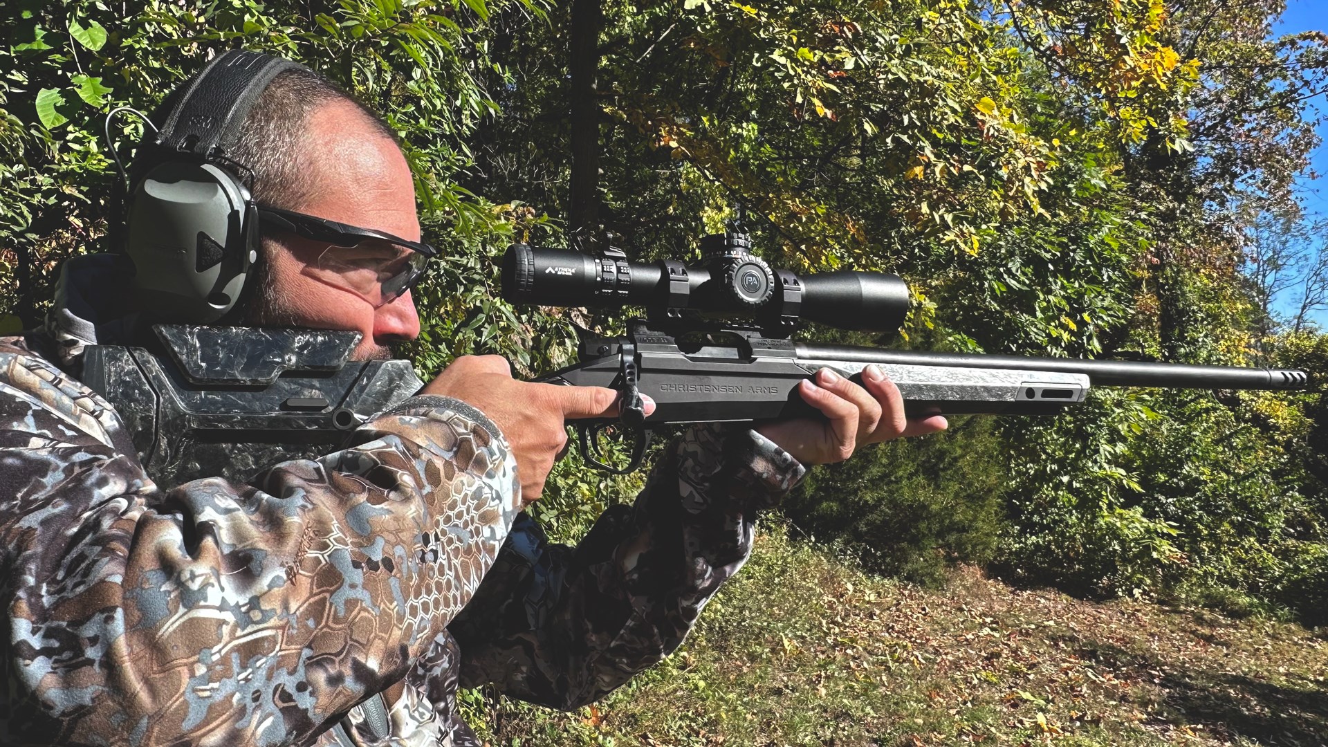Man outdoors wearing camouflage hunter with Christensen Arms Modern Hunting Rifle bolt-action carbon-fiber stock carbon-fiber barrel