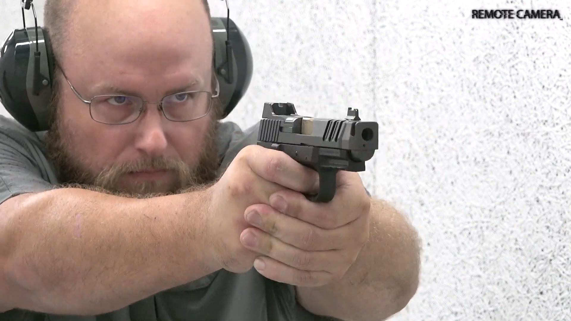 Man firing FN 509 CC Edge pistol indoors hearing protection glasses