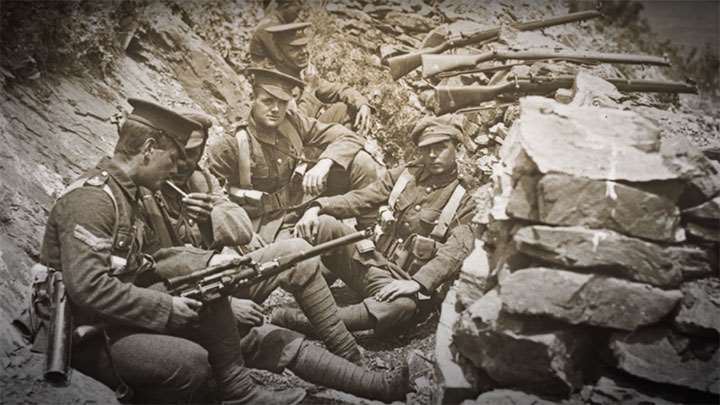 A British soldier sits with his scoped SMLE adapted as a sniper rifle.