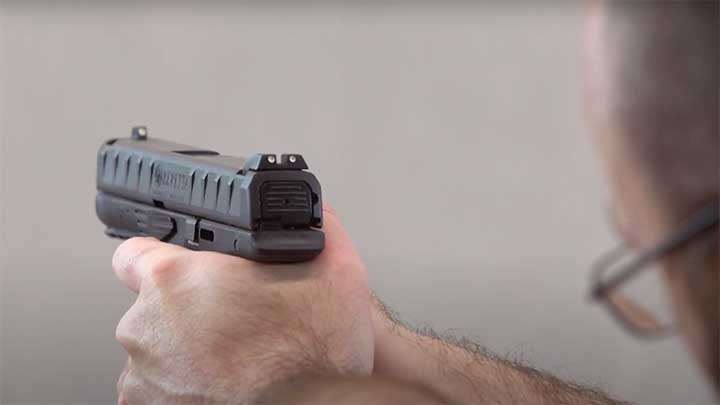 Firing the APX, with the three-dot sights visible.