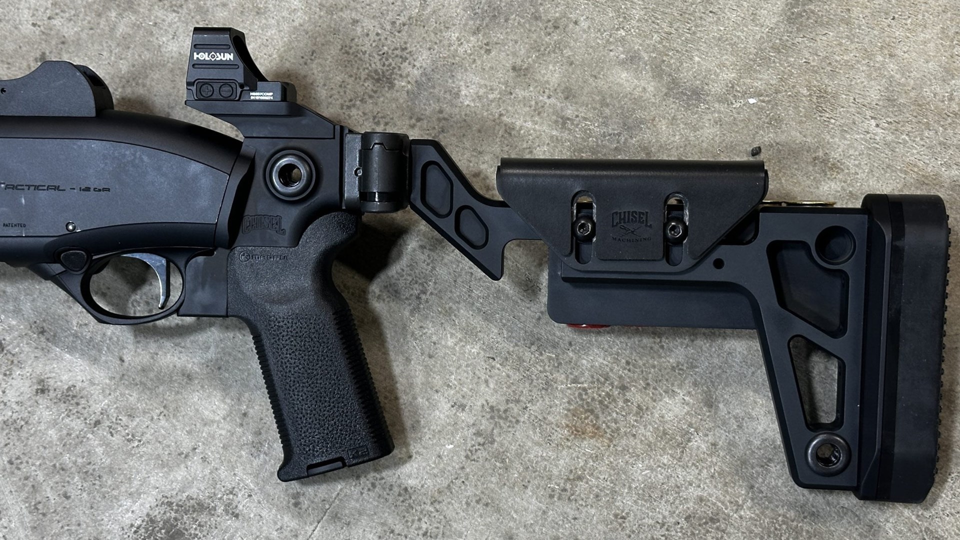 Chisel Machine folding stock left-side view black metal plastic attached to Beretta 1301 shown with Holosun red-dot optic