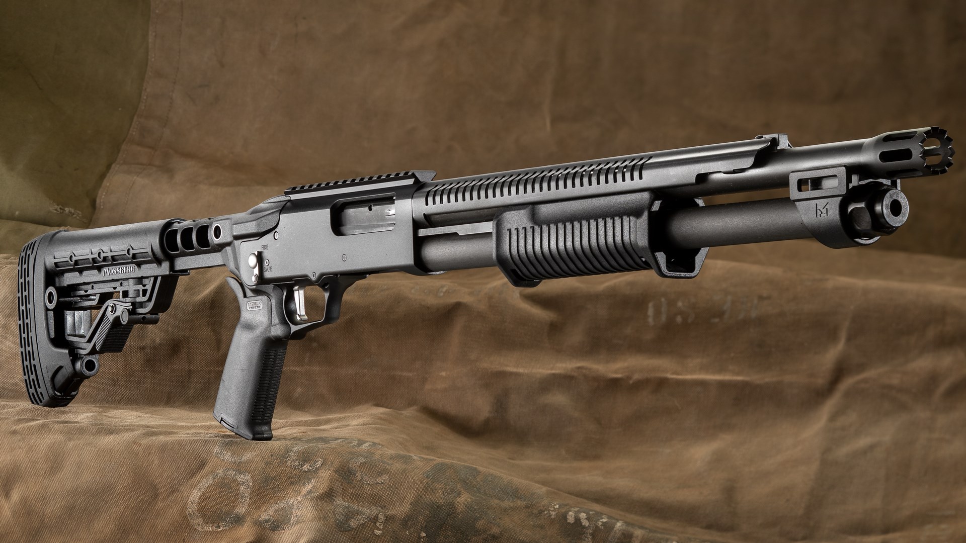 O.F. Mossberg & Sons Model 990R pump-action shotgun right-side dynamic view black gun military canvas background
