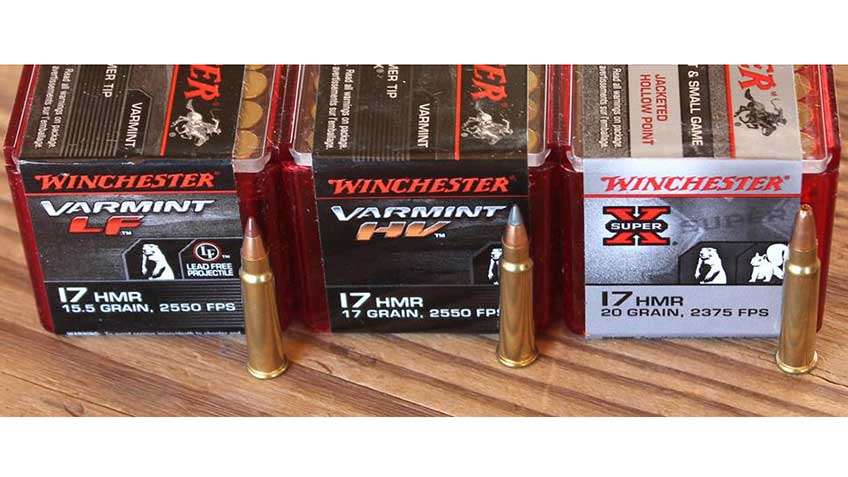 A selection of three loads of Winchester .17 HMR ammunition used in testing, in a row and on wooden table..