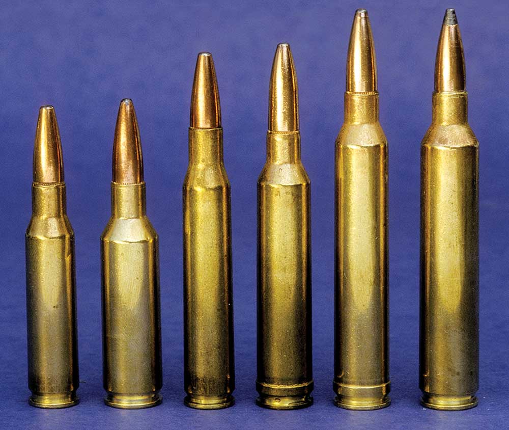 ammunition brass cartridges row lineup six cylinders yellow ammo blue background