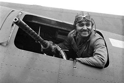 Captain Clark Gable poses with a .50-cal. AN/M2 machine gun