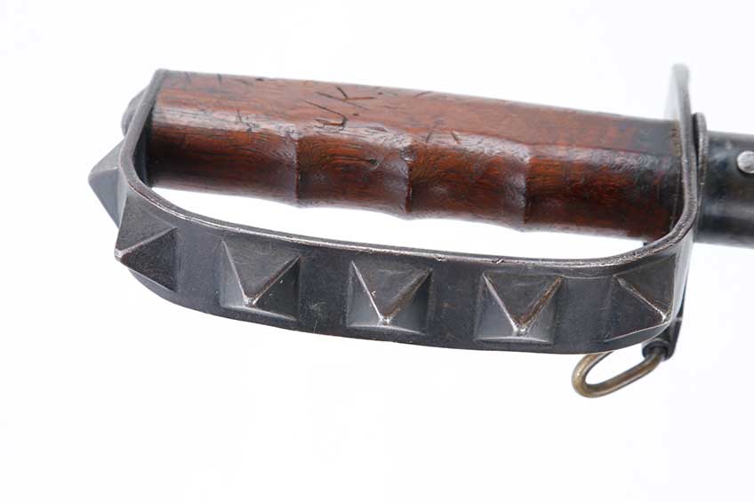 Close-up view of French-made fighting knife handguard with pyramid shaped protrusions.