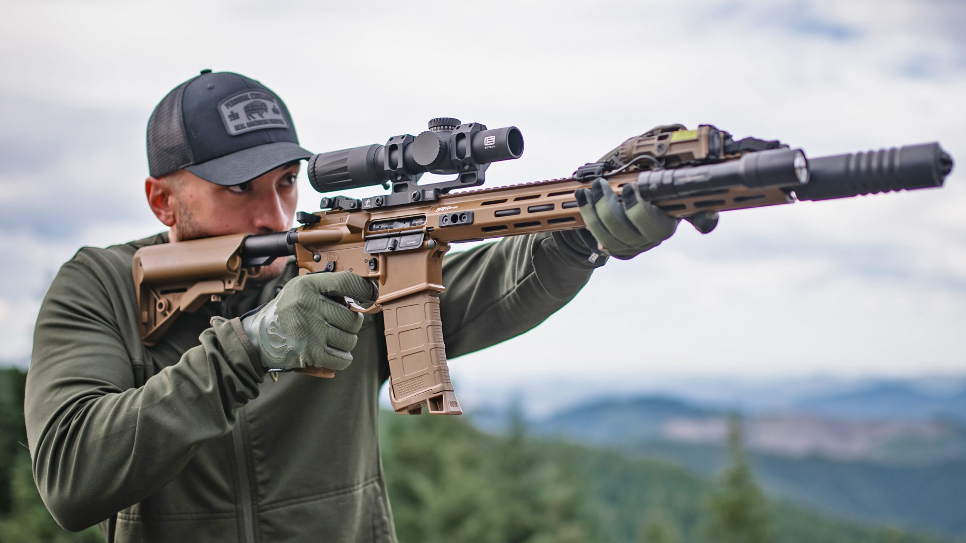 Man shooting a Coyote Brown version of the Springfield Armory Saint Victor AR-15 in a wilderness setting.