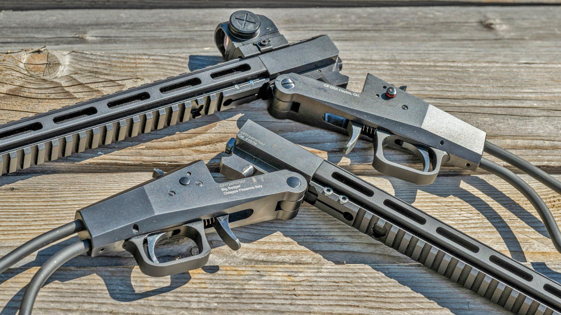 Break-action Chiappa Big Badger rifles shown lying on worn deck boards.