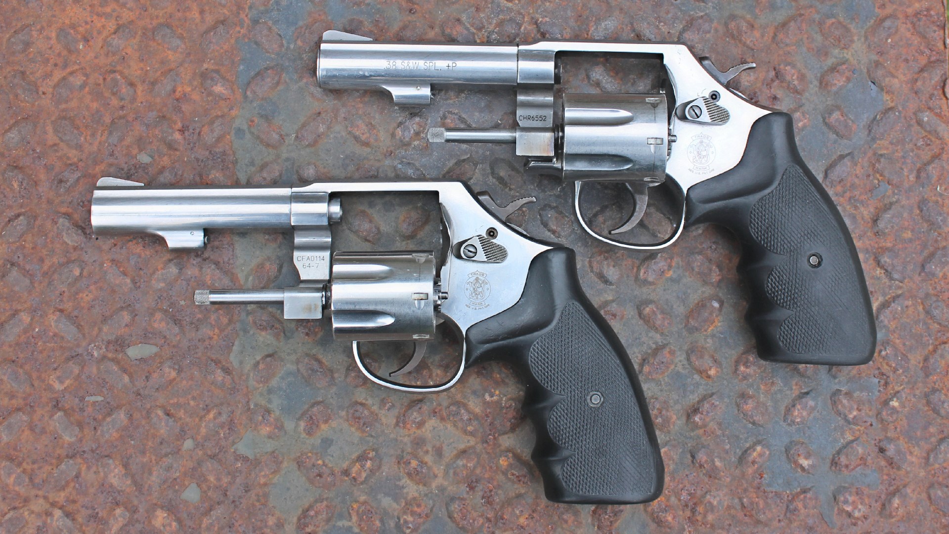 A closer look at the Model 64-7 (Bottom) and 64-8 stainless steel Smith & Wesson revolver (Top) reveals cosmetically subtle but mechanically significant differences in their configurations shown on rusted treadplate.
