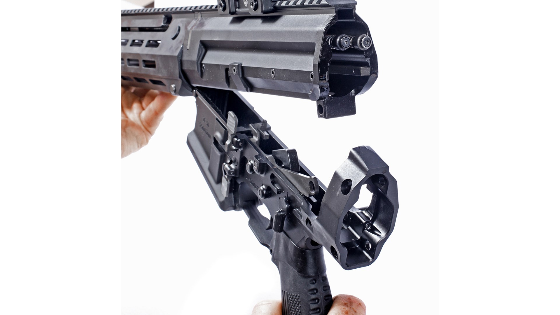 Zenith Firearms MRDS gun receiver halves open hinged upward exposing internal parts white background hands holding