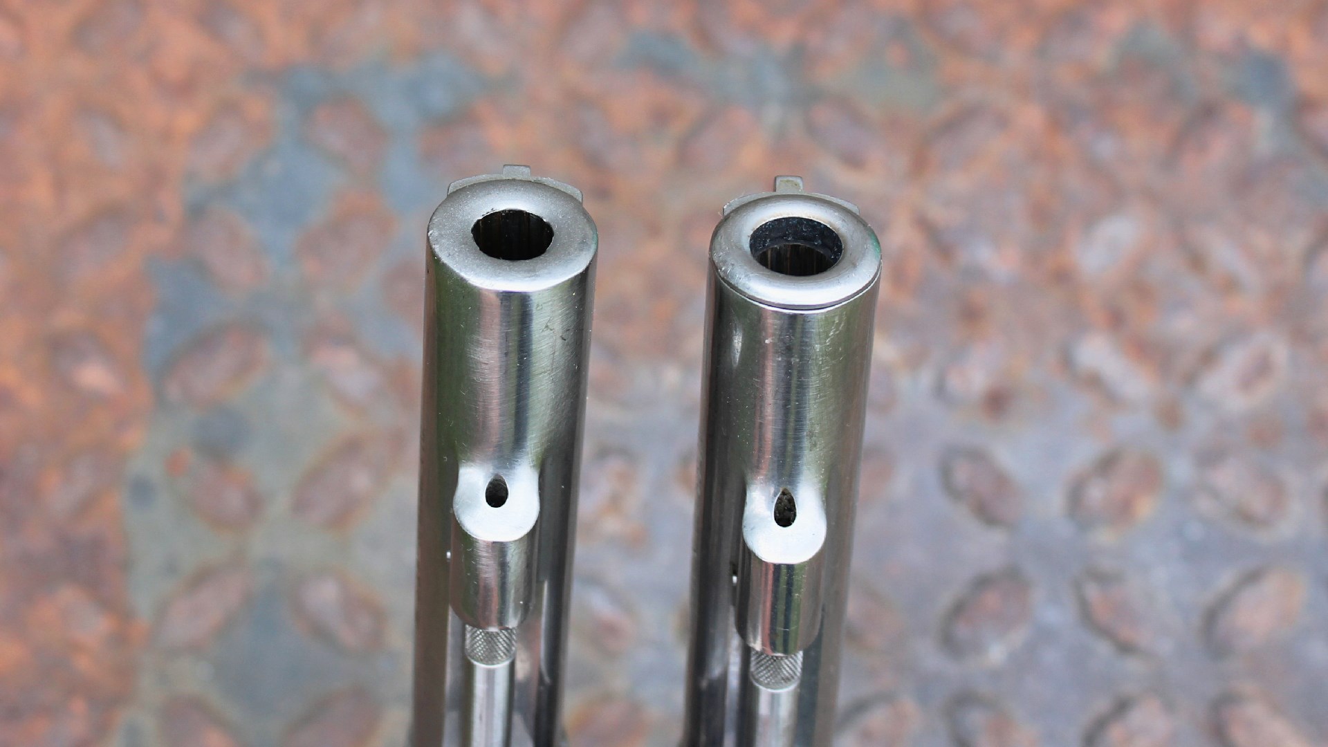Smith & Wesson Model 64 revolver barrels stainless steel side-by-side comparison new old muzzle crown rusted treadplate background
