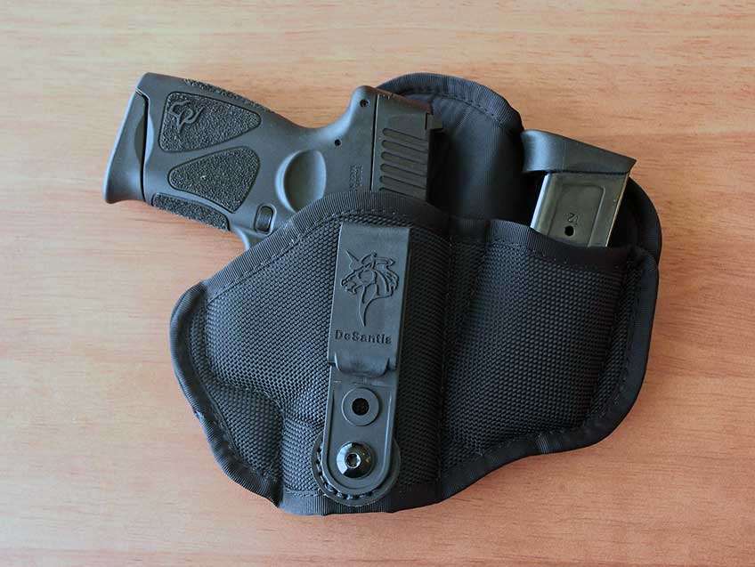 Taurus G3c handgun in DeSantis holster on table